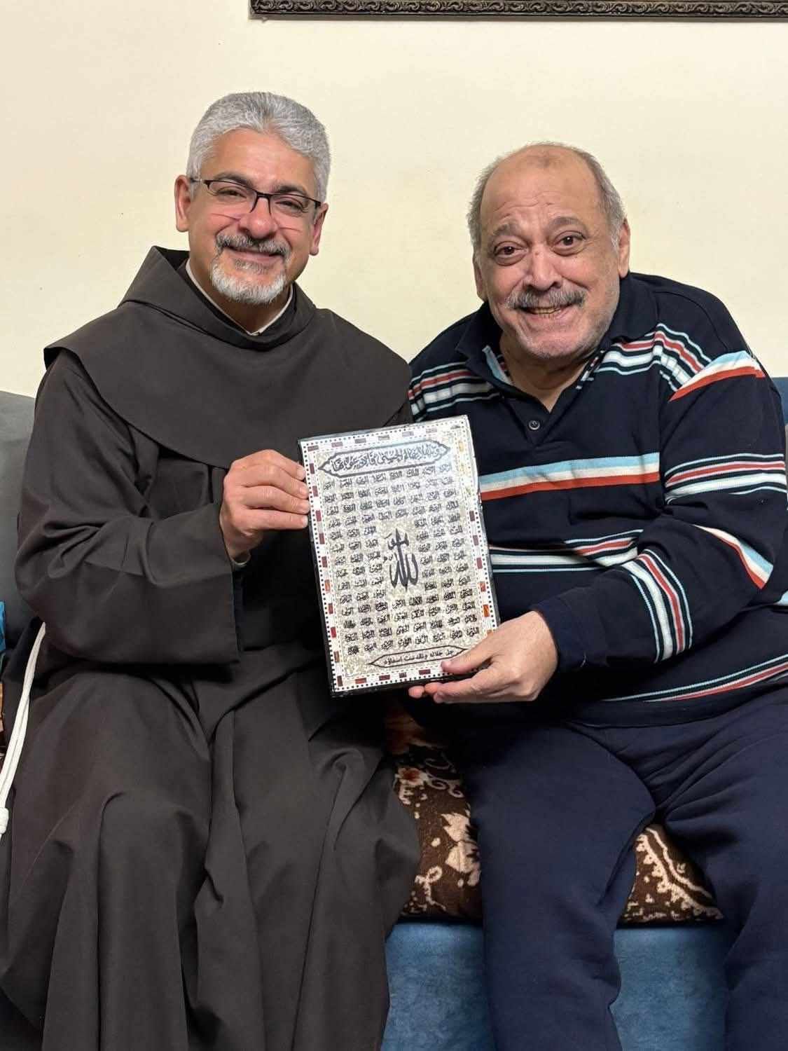 بعد أزمته الصحية.. الأب بطرس دانيال يزور ضياء الميرغني ويهديه لوحة بـ أسماء الله الحسنى