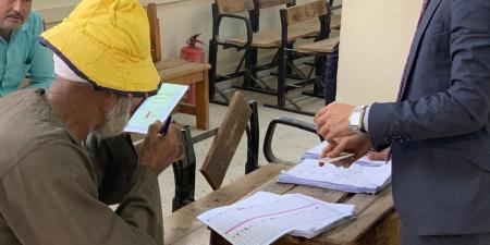 مستشار يساعد كفيف وكبار السن على الإدلاء بأصواتهم في لجنة انتخابية بالزقازيق