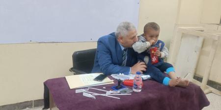 في موقف انساني.. رئيس لجنة في الفيوم يحمل طفل ناخب ليمكن والده من الانتخاب