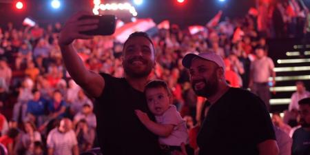 حاتم صلاح وزوجته يشجعان منتخب مصر من العاصمة الجديدة