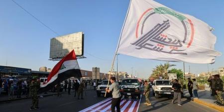 العراق يعتقل “متجاوزين” بحق علم أمريكا خلال استعراض لـ”الحشد”
