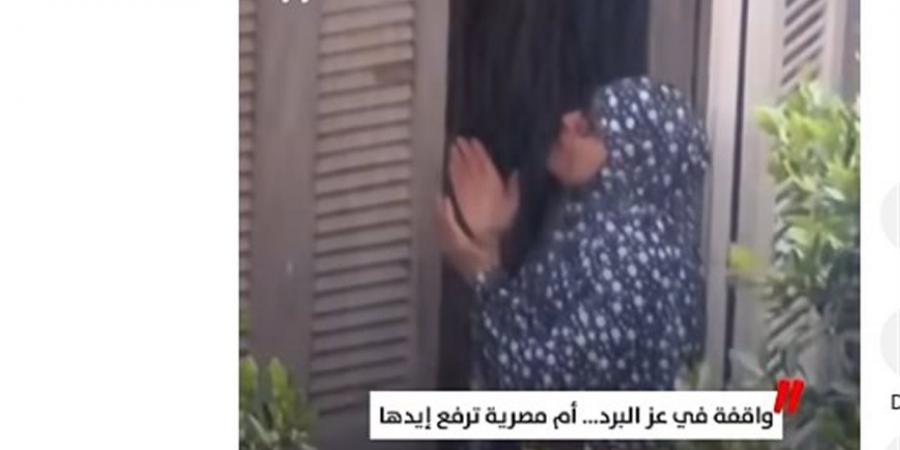 واقفة في عز البرد.. أم مصرية تدعو لأبنائها وسط الأمطار (فيديو)
